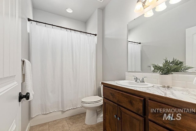 full bathroom with shower / bath combo with shower curtain, toilet, tile patterned floors, and vanity