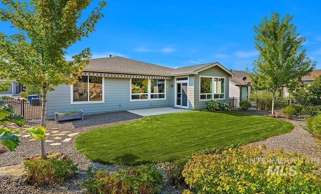 back of house featuring a patio area and a lawn