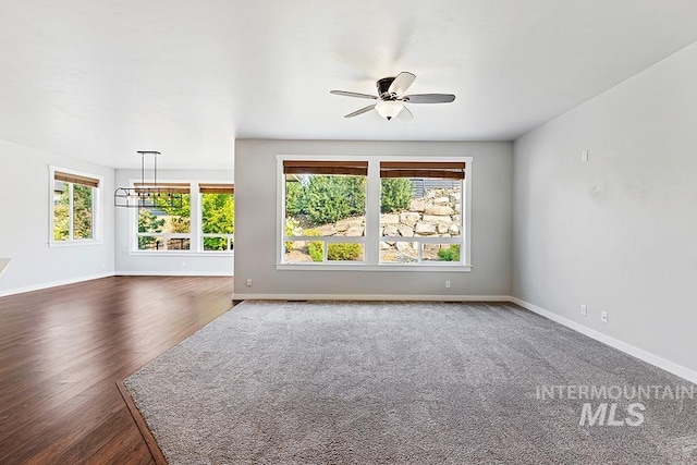 unfurnished living room with ceiling fan and dark wood-type flooring