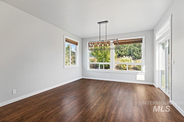 unfurnished dining area featuring a healthy amount of sunlight and dark hardwood / wood-style floors