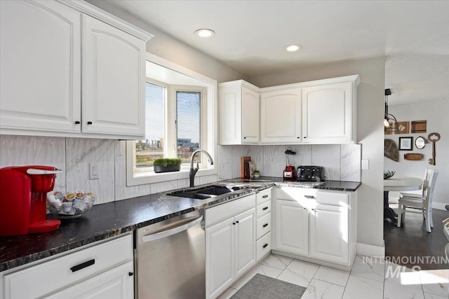 kitchen featuring marble finish floor, a sink, dark countertops, backsplash, and dishwasher