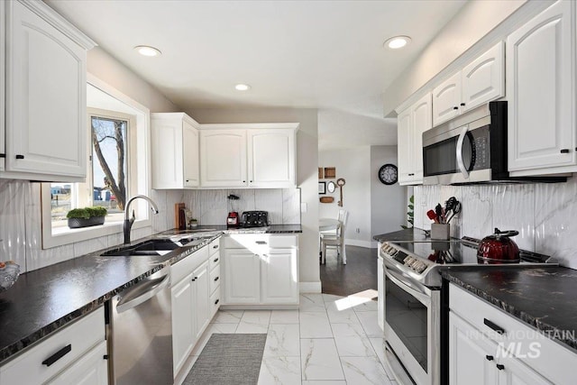 kitchen featuring dark countertops, marble finish floor, white cabinets, and stainless steel appliances