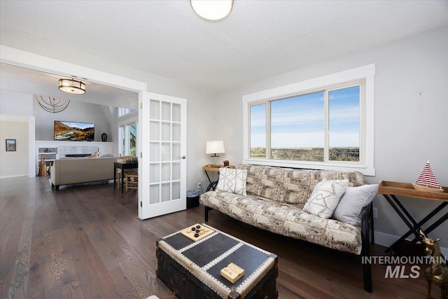 living room featuring dark wood-style flooring and a textured ceiling