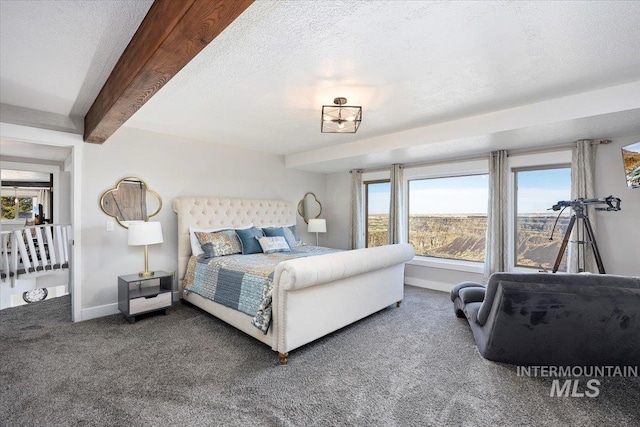 carpeted bedroom with beam ceiling, baseboards, and a textured ceiling