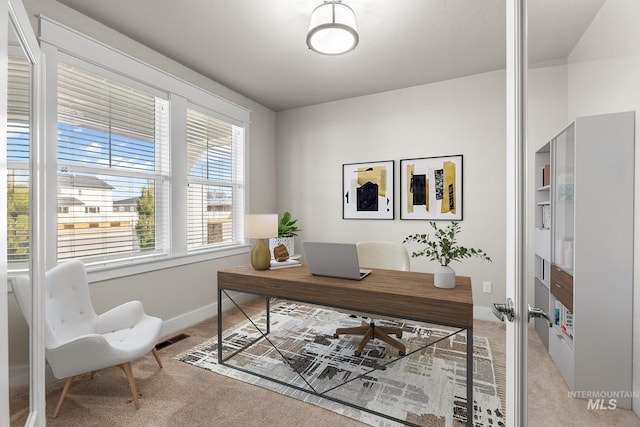 office area with light colored carpet, visible vents, and baseboards