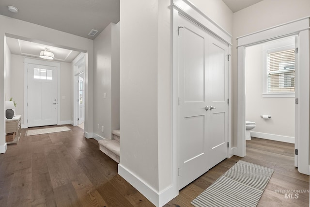 entryway with stairway, plenty of natural light, wood finished floors, and baseboards