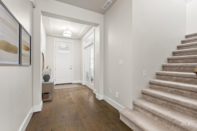 entryway with visible vents, stairs, baseboards, and dark wood-style flooring