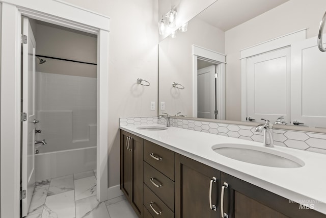 bathroom featuring double vanity, marble finish floor, shower / tub combination, and a sink