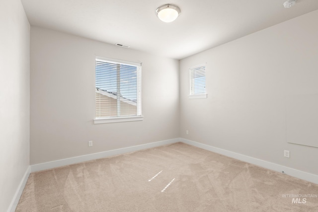 empty room with visible vents, baseboards, and carpet