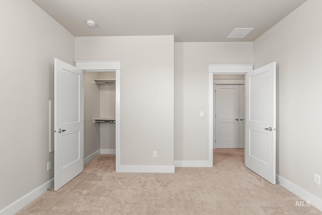 unfurnished bedroom with baseboards, a walk in closet, and carpet