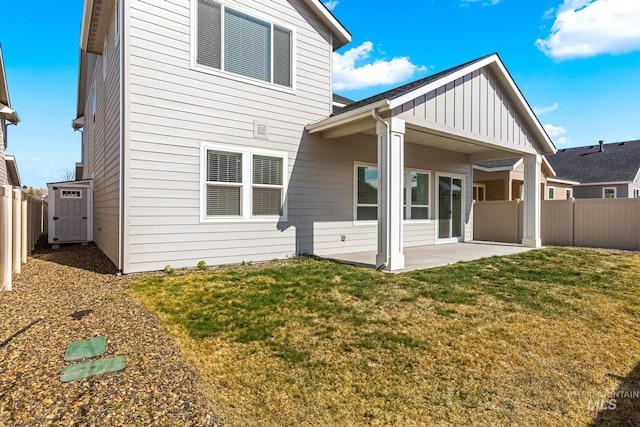 back of property featuring a yard, a patio, board and batten siding, and a fenced backyard