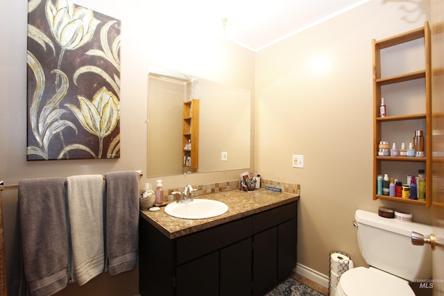 bathroom featuring toilet, baseboards, and vanity