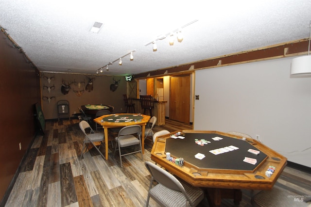 rec room with a textured ceiling and wood finished floors