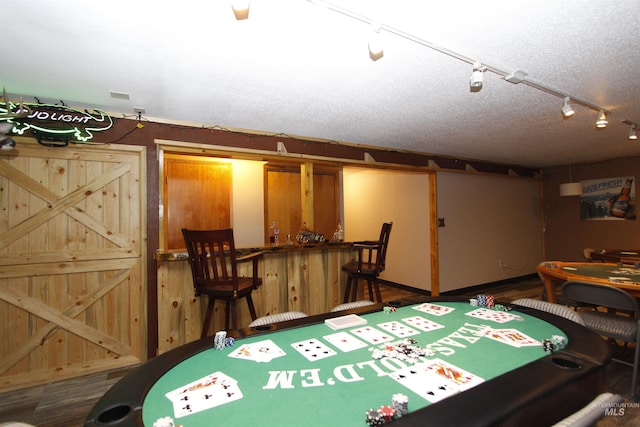 rec room with a textured ceiling and a bar