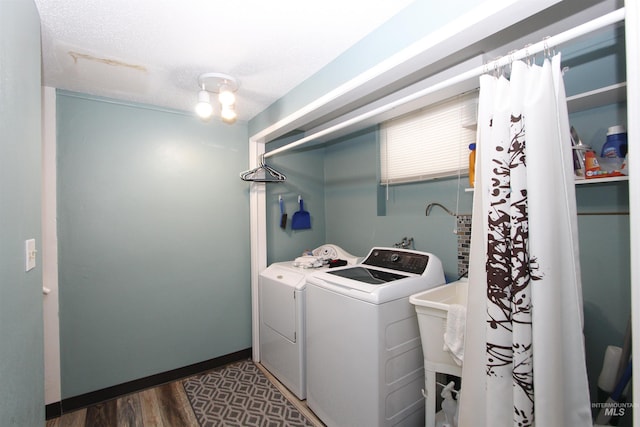 washroom featuring a textured ceiling, dark hardwood / wood-style floors, and washing machine and clothes dryer