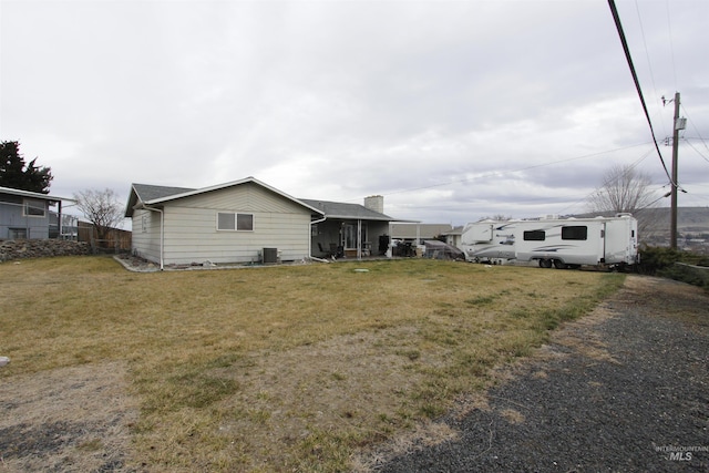 exterior space featuring a yard and central AC