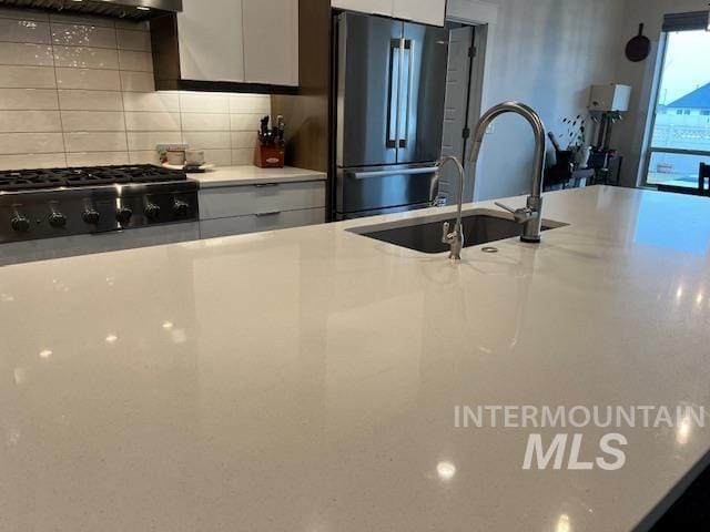 kitchen with white cabinetry, appliances with stainless steel finishes, sink, and decorative backsplash