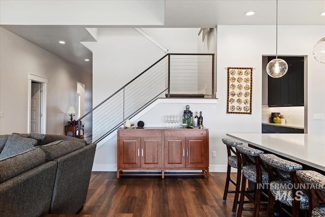 bar featuring hanging light fixtures, dark hardwood / wood-style floors, and decorative backsplash