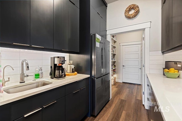 kitchen featuring tasteful backsplash, stainless steel refrigerator, sink, and dark hardwood / wood-style floors