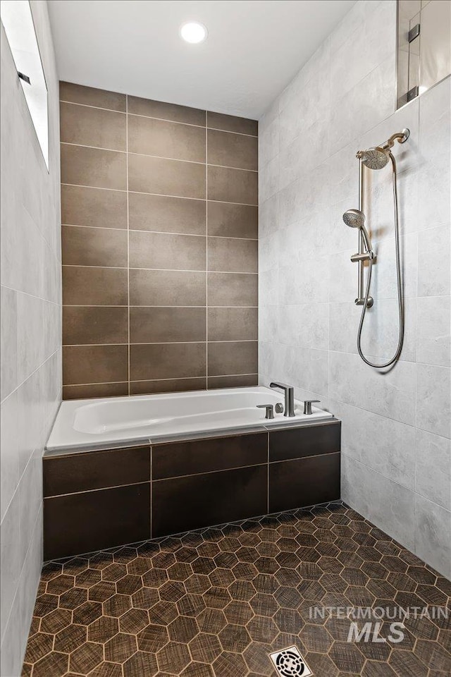 bathroom with tile walls and separate shower and tub