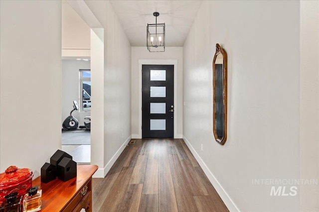 foyer featuring wood-type flooring and a chandelier