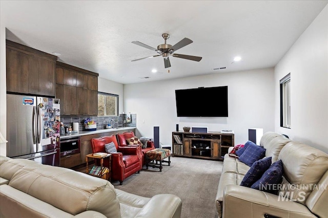 carpeted living room with ceiling fan