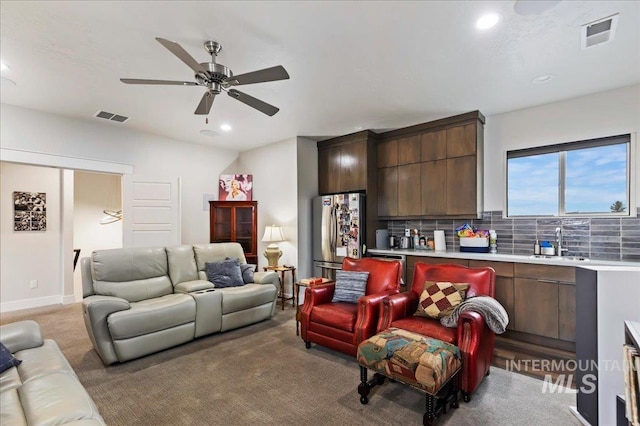 carpeted living room with sink and ceiling fan