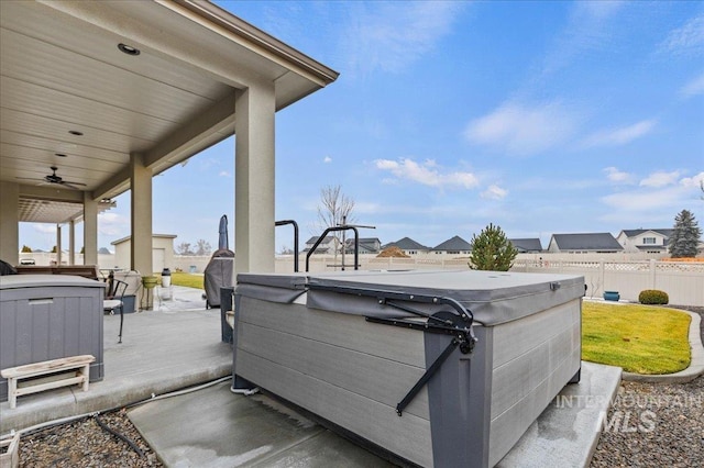 view of patio with ceiling fan and a hot tub