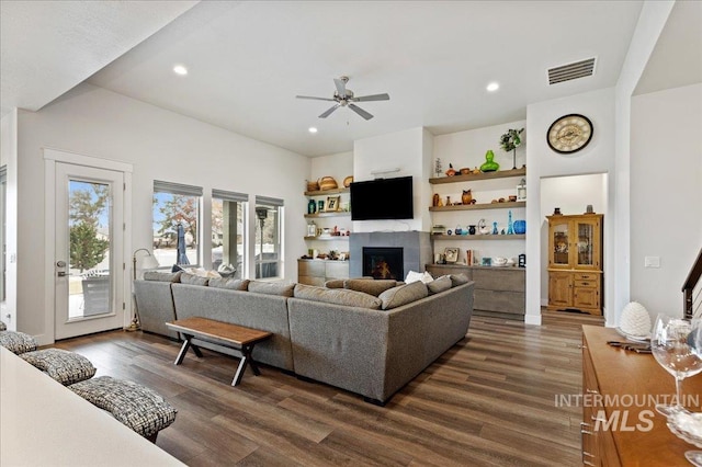 living room featuring dark wood-type flooring and ceiling fan