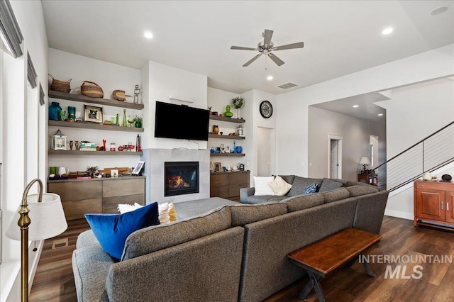 living room with ceiling fan, dark wood-type flooring, and a fireplace