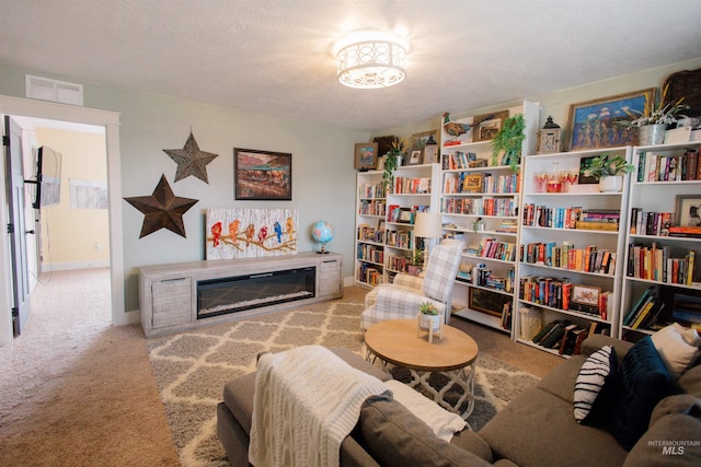 carpeted living room with a glass covered fireplace