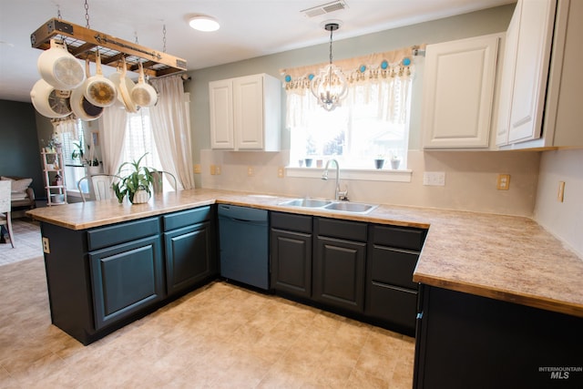 kitchen with a sink, dishwasher, a peninsula, a chandelier, and healthy amount of natural light