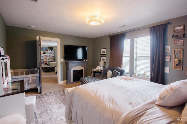 bedroom with carpet flooring and a fireplace