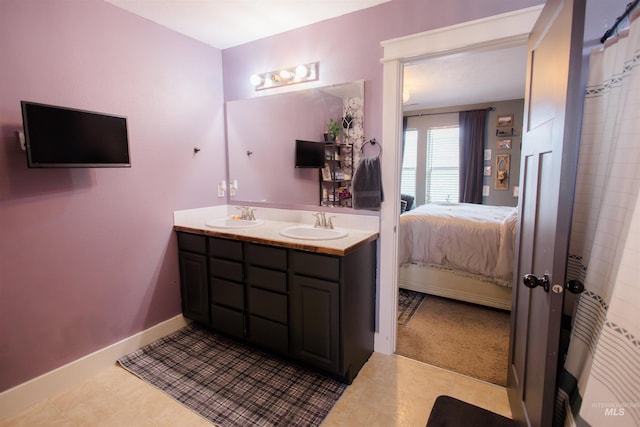 ensuite bathroom with double vanity and baseboards
