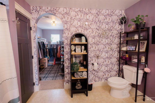 bathroom featuring toilet and a walk in closet