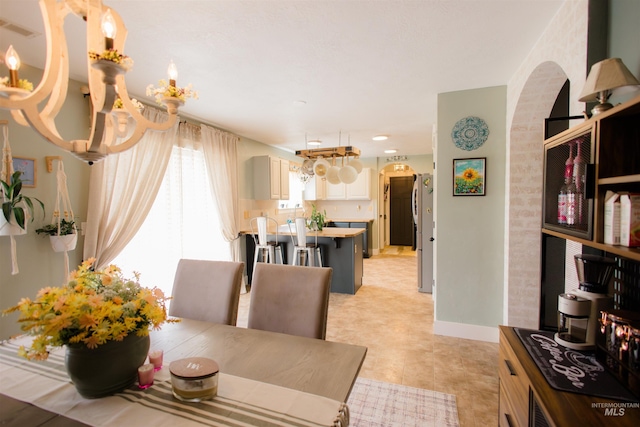 dining area with arched walkways and baseboards