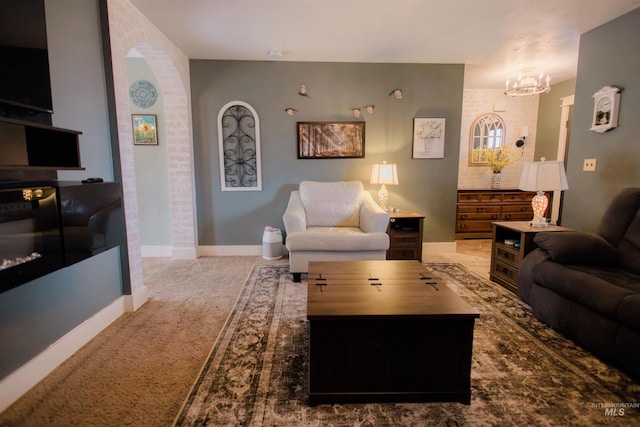 carpeted living room featuring a chandelier and baseboards