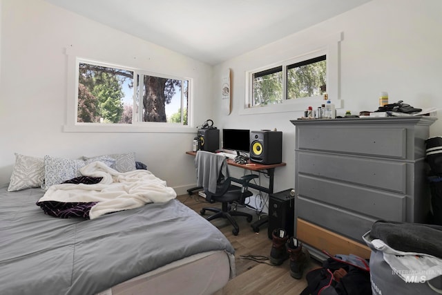 bedroom with wood-type flooring and vaulted ceiling