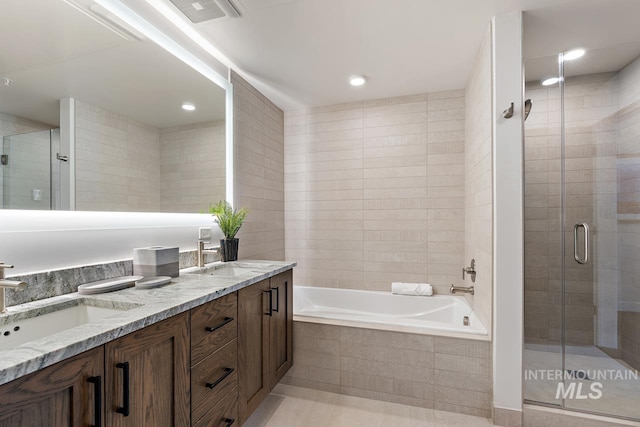 bathroom with vanity, shower with separate bathtub, tile walls, and tile patterned floors