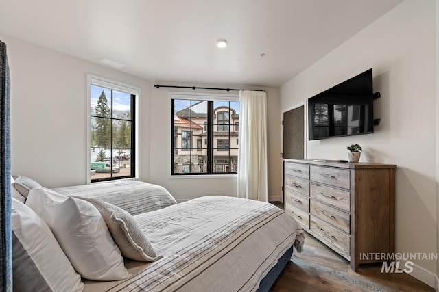 bedroom with dark hardwood / wood-style flooring