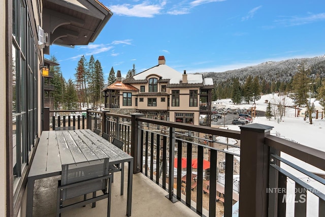 snow covered back of property with a mountain view