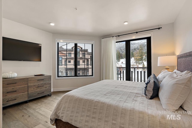 bedroom featuring access to exterior and light wood-type flooring