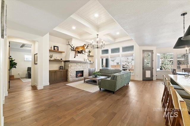 living area featuring baseboards, coffered ceiling, hardwood / wood-style floors, a notable chandelier, and beam ceiling