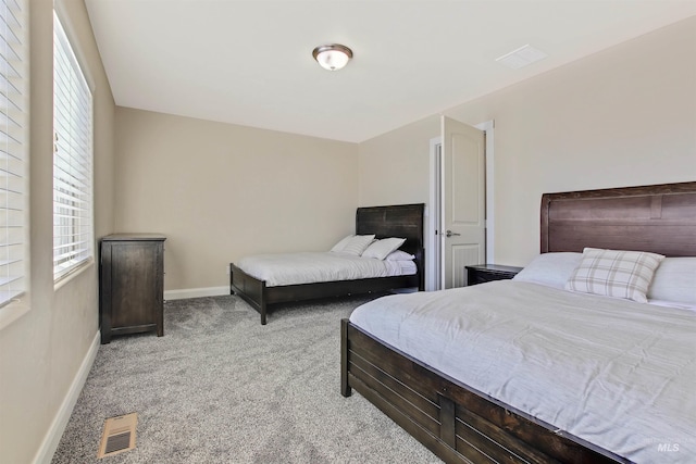 bedroom with light colored carpet and multiple windows