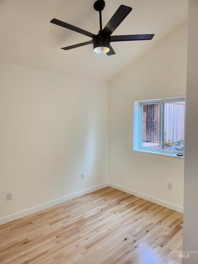 spare room featuring lofted ceiling, wood finished floors, a ceiling fan, and baseboards