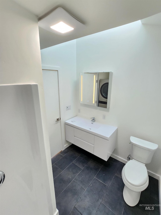 bathroom featuring baseboards, vanity, toilet, and tile patterned floors