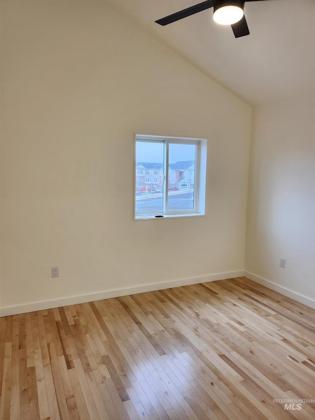 empty room with light wood-type flooring, baseboards, a ceiling fan, and lofted ceiling