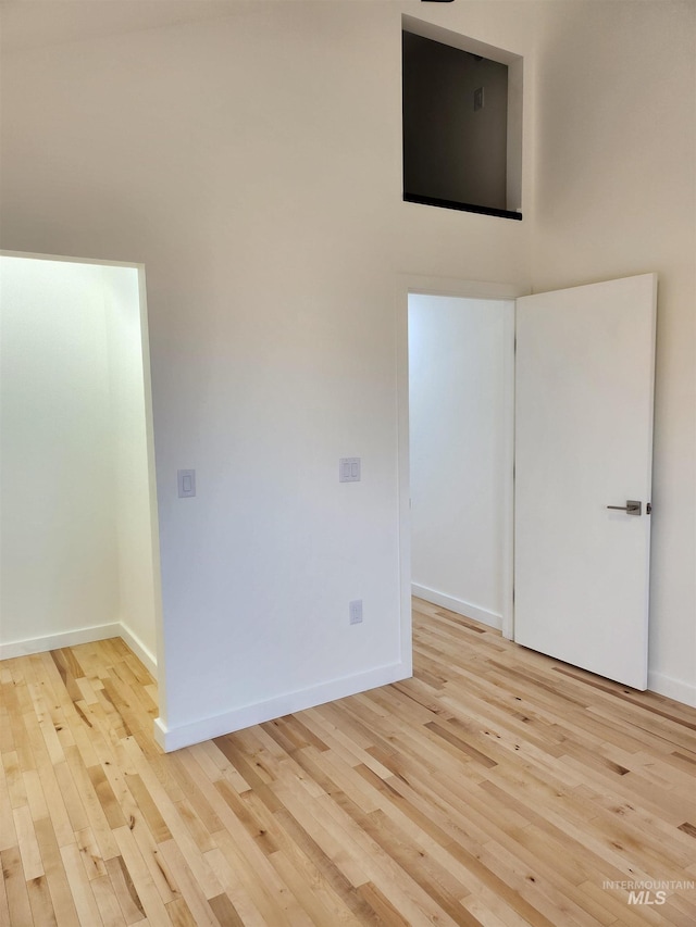 spare room with baseboards and wood finished floors