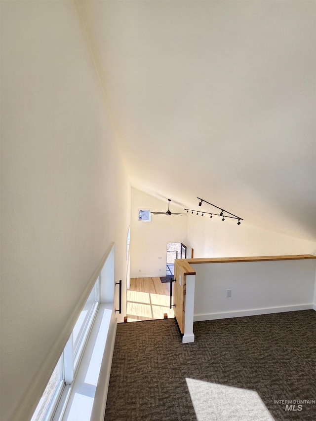 interior space with carpet flooring, vaulted ceiling, and baseboards