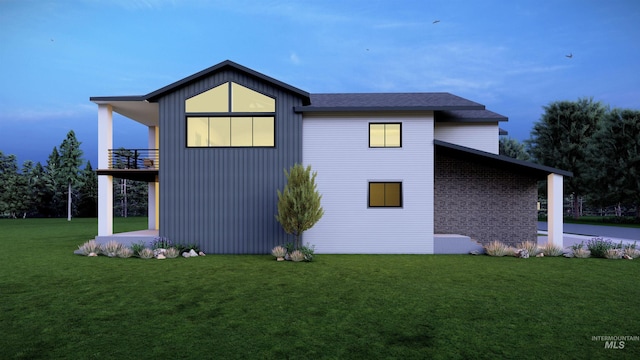 view of home's exterior with a balcony, a lawn, and brick siding